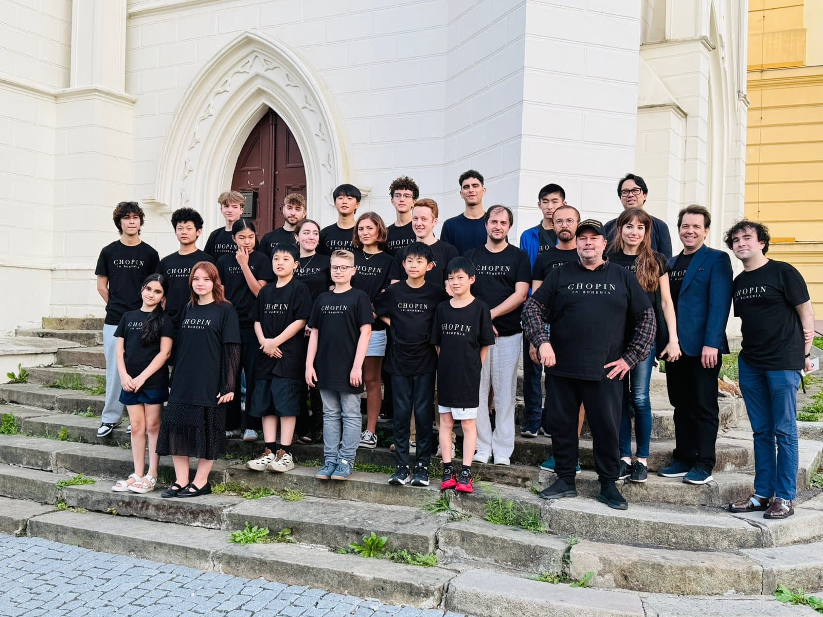Students and faculty of Chopin in Bohemia on the church steps in Teplice, in festival shirts